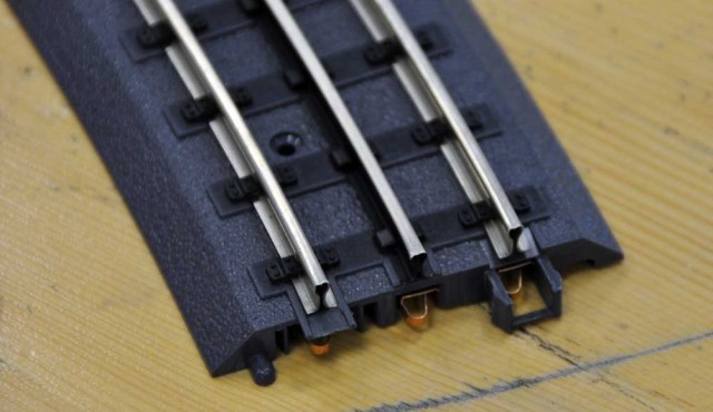 Voie MTH "3 rails" et assemblage. Cette voie évoque la voie HO Marklin C par le système mécanique d'assemblage et de connexion électrique.