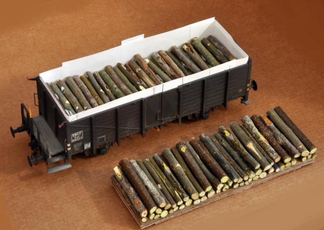 Des tombereaux ont reçu des chargements de bois. Des languettes de papier sont placées pour conserver un espace suffisant pour placer et ressortir le chargement, et le coller sans risque pour le wagon.<br /><br />Des épaisseurs de carton ondulé sont utilisées afin de gagner du temps. Les châssis Lenz sont assez lourds pour ne pas être lestés, et cette solution convient pour cela. C’est évidemment la même méthode qui peut être employée à différentes échelles. à droite, exemple de « plancher » dessiné et mis en couleur et texture à l’ordinateur. Une finition à la terre à décor est utile.