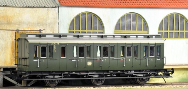 rançois nous explique l'origine et les travaux effectués sur ces voitures.<br />Lenz - Voiture prussienne B3pr11 en version DB 1ère classe post changement de classe en 1956.<br />La voiture à 3 essieux sans vigie fabriquée par Lenz est la version avec macaron DB, bande de 1ère classe ivoire et peinture verte « oxyde de chrome » plutôt à dater de 1958. Cette mise à niveau ne fut pas générale car l’exploitation de ces voitures se termina en 1962 lorsque la DB élimina du service commercial toutes les voitures en bois tôlé. Cette voiture est d’un type identique à la B5tf de la SNCF (avant 1956) telle que proposée par Chrezo.