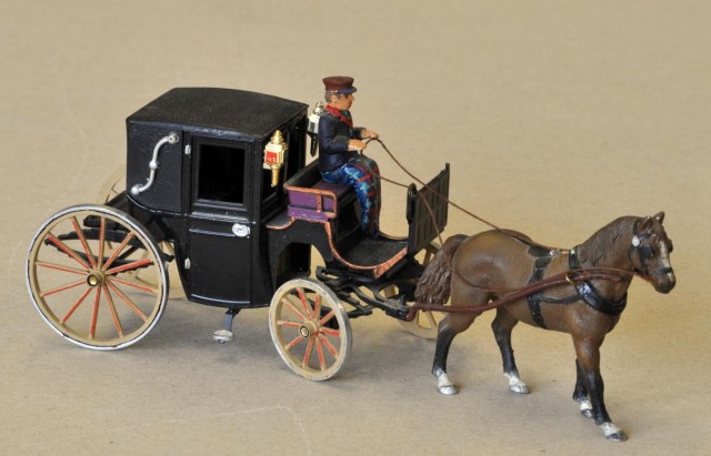 Cette photo et les deux suivantes :<br />BRUMM, le fabriquant italien de voitures a produit il y a une bonne décennie un lot de véhicules hippomobiles « historiques ». Si certains sont très typés et anciens, le fiacre est plus passe partout. Celui-ci venait avec ou sans son cheval. Toutefois, j’ai abandonné celui-ci dont l’harnachement en plastique manquait de souplesse pour lui mettre à nouveau un cheval en métal blanc. à noter que le cheval mangeant dans son sac est en fait un ALADIN CAVE, gamme reprise par LYNX MODELS (je n’ai pas retrouvé la référence) https://www.lynxmodels.net/castings.html