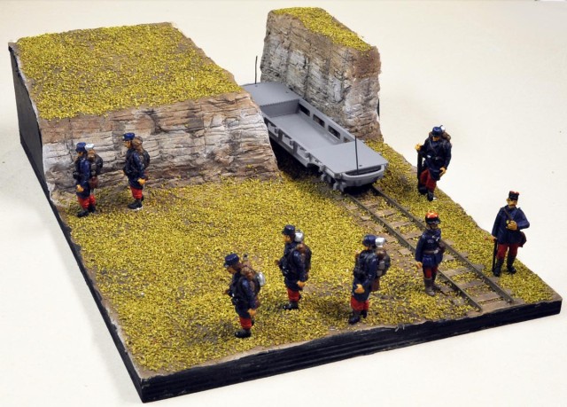 02 - Un diorama mettant en valeur les figurines PLM Castaway des soldats français de la guerre de 14 (ils sont encore en veste bleue et pantalon garance ! - le célèbre « bleu horizon » n’arrivant qu’en 1916). Une petite voie étroite avec un wagon PECHOT (impression 3D trouvé sur SHAPEWAYS) complète l’ensemble. Un espace a été laissé libre à fin de pouvoir intégrer un camion Berliet ou une auto-mitrailleuse Peugeot. Les reliefs sont réalisés en carton de calendrier recouvert de DAS (acronyme anglais pour pâte à modeler autodurcissante à l'air), mis en teinte par du Panel Line Accent Color de TAMYA, après échanges avec Daniel67 sur le Forum du Zéro.