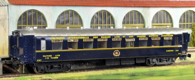 François a posé sur le diorama photo cette Voiture-Lits CIWL. Voici ses explications toujours précises et circonstanciées.<br />     La voiture CIWL est une voiture lits Night-Ferry au gabarit britannique et équipée du frein à vide en plus du frein à air continental, dans sa version d’avant 1956 puisque réservée aux seuls titulaires de billets de 1ère et 2ème classe ! Le Night Ferry était constitué au minimum de 3 couplages (un couplage comportait 2 voitures attelées avec les portes en vis-à-vis pour permettre à un seul conducteur des wagons-lits de gérer l’embarquement des passagers des 2 voitures) et de 2 fourgons Nord avec marchepieds étroits, l’un avec le compartiment du chef de train, l’autre dédié exclusivement au transport de bagages.<br /><br />      Le modèle présenté a été réalisé et vendu par David Moxon au début des années 80, artisan anglais spécialiste des kits de voitures au 1/43. La fabrication fait appel à une caisse en aluminium roulé sur laquelle sont collées des photogravures pour figurer le toit avec ses bandes de recouvrement rivetées, les bouts de caisse et toutes les pièces de détail étant moulées finement en métal blanc. Le châssis est une plaque de bois « colonial » imputrescible sur lequel sont fixés les accastillages (bacs à batteries, cylindres de frein, etc.) ainsi que les bogies, tous moulés en métal blanc également. L’aménagement intérieur est quant à lui en carton. Des semi-kits (caisse montée et décorée, bogies et aménagements intérieurs à monter et à décorer) ont été alors proposés aux membres du Cercle du Zéro par Jean Villette qui avait assuré la traduction de la notice de montage.<br /><br />      Ce modèle fut ressorti il y a une dizaine d’années par Westdale (Dick Taylor) qui avait repris et développé la gamme démarrée par David  Moxon. Le modèle était toujours constitué d’une caisse en aluminium roulé sur laquelle étaient collées des photogravures pour figurer le toit avec ses bandes de recouvrement rivetées et cette fois-ci les « matelas » (couvercles des bâches à eau disposées en toiture au-dessus des toilettes) absents du modèle Moxon. Les bouts de caisse étaient désormais moulés en résine et les pièces les plus exposées comme les marchepieds en fonderie de laiton. L’aménagement intérieur (cloisons ) était dorénavant en photogravure et les lits en résine. Comme c’est souvent le cas en Angleterre, les bogies provenaient d’un autre artisan : créés à l’origine par Cavalier, ils avaient été repris par ABS Models. à cette voiture « actualisée », Dick Taylor avait rajouté à son « catalogue » les différentes versions des fourgons Night Ferry avec une caisse exacte en résine.
