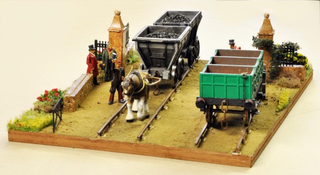 Quelques mots de Pierre : Même si on ne sait pas trop si l’on est dans la campagne anglaise ou dans le Massif Central, « 1830 » est un diorama dont le titre donne la période. Il a été construit sur un A4 afin de participer au challenge organisé par Loco-Revue lors de Trains-Mania 2019. à noter que la voie est de l’impression 3D, les véhicules sont issus du catalogue d’artisans anglais, et les personnages de différentes productions britanniques.