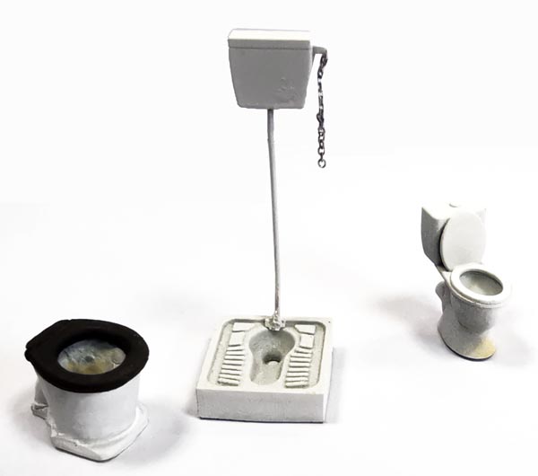à gauche : toilettes achetées sur le site de Bois Modélisme. C’est une fabrication LUDO MODELISME. Pierre a trouvé les toilettes dames (à droite) trop modernes et un peu petites. Aussi, il leur a préféré un kit en métal blanc ramené d’Angleterre il y a des années (à gauche).