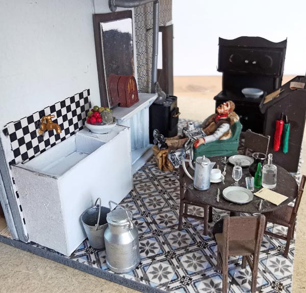 La vaisselle, les verres, les couverts, et autres viennent du bric-à-brac accumulé depuis des années. <br /><br />Les verres et les bouteilles sont des kit au 1/35 (tout comme la bassine en zinc pour se laver !) de chez MINIART. Les couverts sur la table sont des produits HAXO MODELES, le reste a souvent été trouvé à la GUILDEX. La radio sur le manteau de la cheminée est achetée chez AUBERTRAIN.<br /><br />Le bâtiment est à terminer.<br /><br />L’aménagement a été un vrai casse-tête, car il a fallu imaginer à quoi ressemblait l’intérieur d’une maison de garde-barrières. Assez peu de documents étaient disponibles.