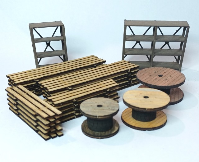 Trouvé en ligne par hasard, le set 67140 de NOCH propose deux étagères, trois tourets de câbles et quatre piles de planches, tout en découpe laser. Des essais de mise en couleur ont déjà eu lieu.
