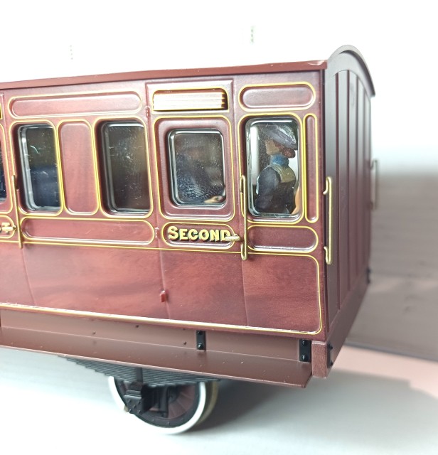DAPOL a créé des voitures 3ème/fourgon et mixte 1ère/2ème acquises par Pierre. Il existe également des voitures de 1ère, 2ème et 3ème pour compléter la rame. <br />La presse britannique a loué la qualité de reproduction de l’acajou en peinture. <br />A noter que sur le LBSC, la seconde classe fut abolie vers 1909.<br /><br />Acquises d’occasion, plusieurs figurines (en métal blanc !) peuplent certains compartiments !<br />Ces voitures sont destinées à être tractées par de petites locomotives TERRIER de chez DAPOL dont Pierre possède une demi-douzaine d’exemplaires.